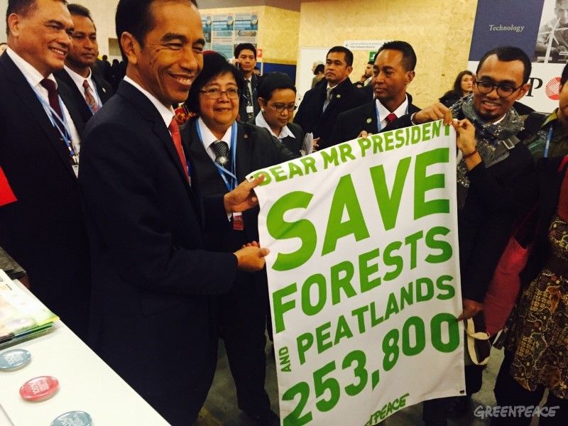 Indonesian President Joko WIdodo holds a banner referencing the support of 253,800 people for saving Indonesia's forests and peatlands at the climate talks in Paris in December 2015. Photo courtesy of Greenpeace