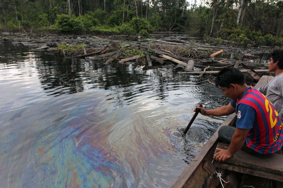 CUNINICO, Peru–Villager examine oil slick near this Kukama Indian village in the northeastern Peruvian Amazon. Photo by Barbara Fraser.