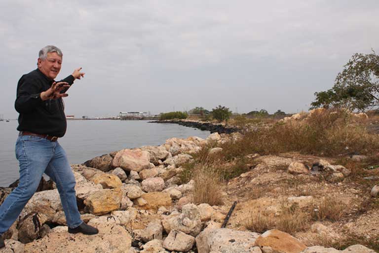 Alfredo Borges, environmentalist and former PDVSA employee points out oil-blackened rocks at a spot where daily “micro-spills” occur in Lagunillas on Lake Maracaibo. Photo by Jeanfreddy Gutiérrez Torres