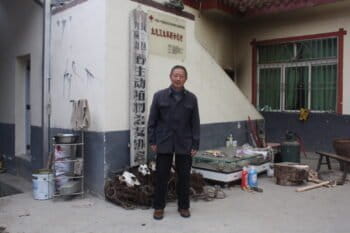 Yu Jiahua poses in front of a small portion of the wire loops collected by the anti-poaching patrol team during the past two decades. Photo by Wang Yan.
