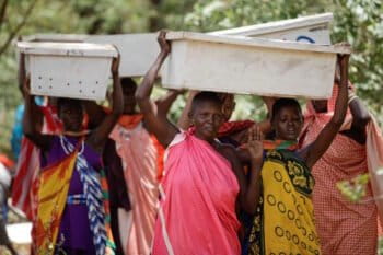 Tanzanian women carry new beehives into the forest. Photo by Felipe Rodriguez/APW