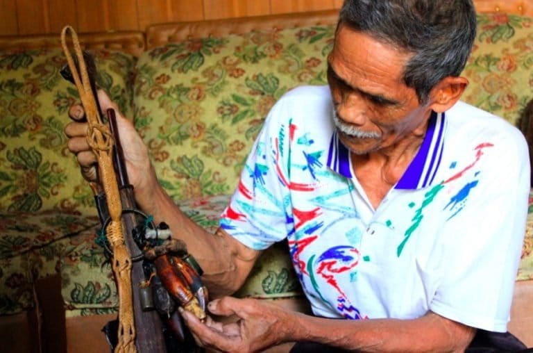 Iber Djamal shows off the tiger fangs on his mandau. Photo by Jemmie Delvian