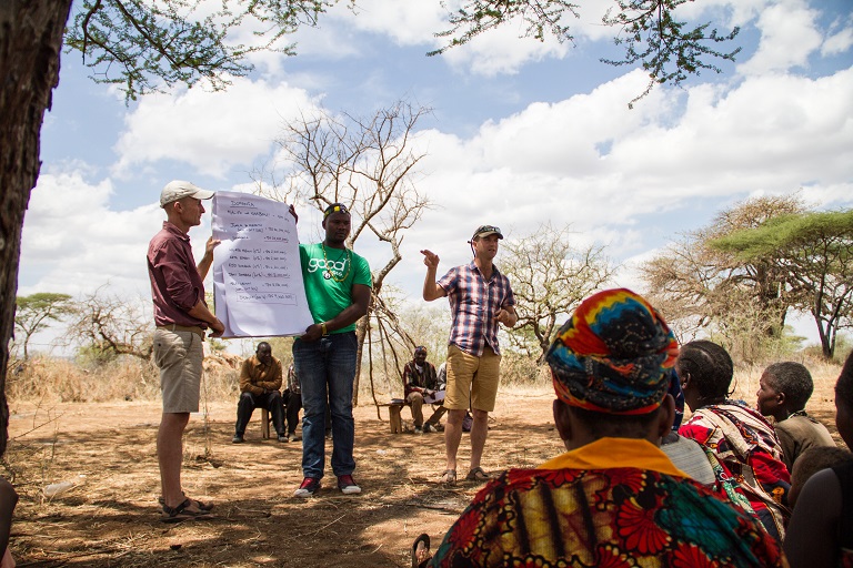 Jo Anderson, co-founder and director of finance and sales at Carbon Tanzania, presents the bi-annual profits from carbon sales during a community meeting in Domanga village in Yaeda Valley. It is up to the community to decide how to spend the money. Photo by Sophie Tremblay for Mongabay. 