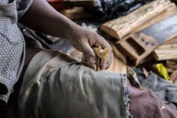 A woodcarver makes a carving of a rhinoceros on the outskirts of Lunga Lunga, a town on the border between Kenya and Tanzania. Photo by Nathan Siegel for Mongabay