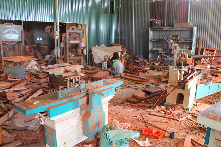 Chu Van Nhung's dusty furniture workshop. Photo by Michael Tatarski for Mongabay.