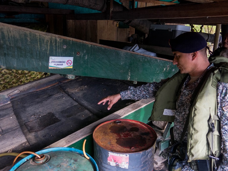 Maj. Edgar Hernándo Jaimes Súarez explains how gold is extracted from the river sediments on a draga. Photo by Bram Ebus for Mongabay.