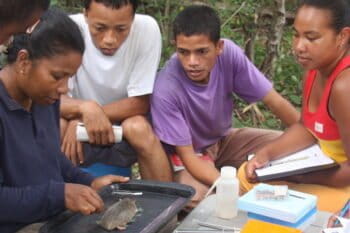 With a greater hedgehog tenrec (Setifer setosus) stretched out on her lap, Voahangy Soarimalala of Association Vahatra demonstrates measurement techniques for small mammals to a group of masters students from the University of Antananarivo in the Andranomena Special Reserve. Photo courtesy of Association Vahatra.