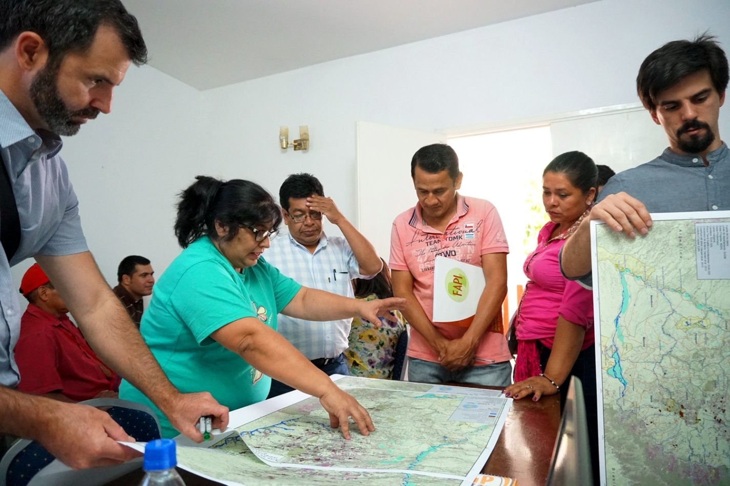 Mirta Pereira, legal advisor of FAPI; Alberto Vázquez; Sindulfo Miranda, president of the Che Iro Ara Poty association, of the Mbya Guaraní people; and Amada Martínez discussing maps during the planning workshop. 