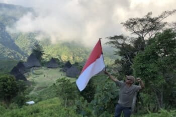 A tourist from Jakarta poses with the Indonesian flag. Image by Sarah Hucal for Mongabay.