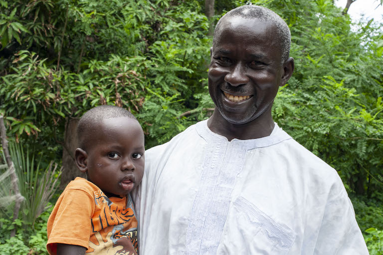 Bassirou Sambou, who heads the biodiversity monitoring section of Kawawana, with his grandchild. Image by Jennifer O’Mahony for Mongabay.