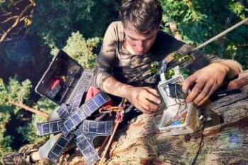 Topher White of Rainforest Connection installing a bioacoustic device in the forest canopy. Image by Ben Von Wong.
