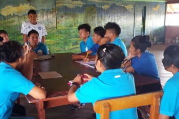 Student government president Gaymon Edwards leads a meeting of his fellow students. Their current requests from the school administration include sprinklers for the kitchen garden, new locks for the classrooms, and full electricity in the dorms. Image by Carinya Sharples for Mongabay.