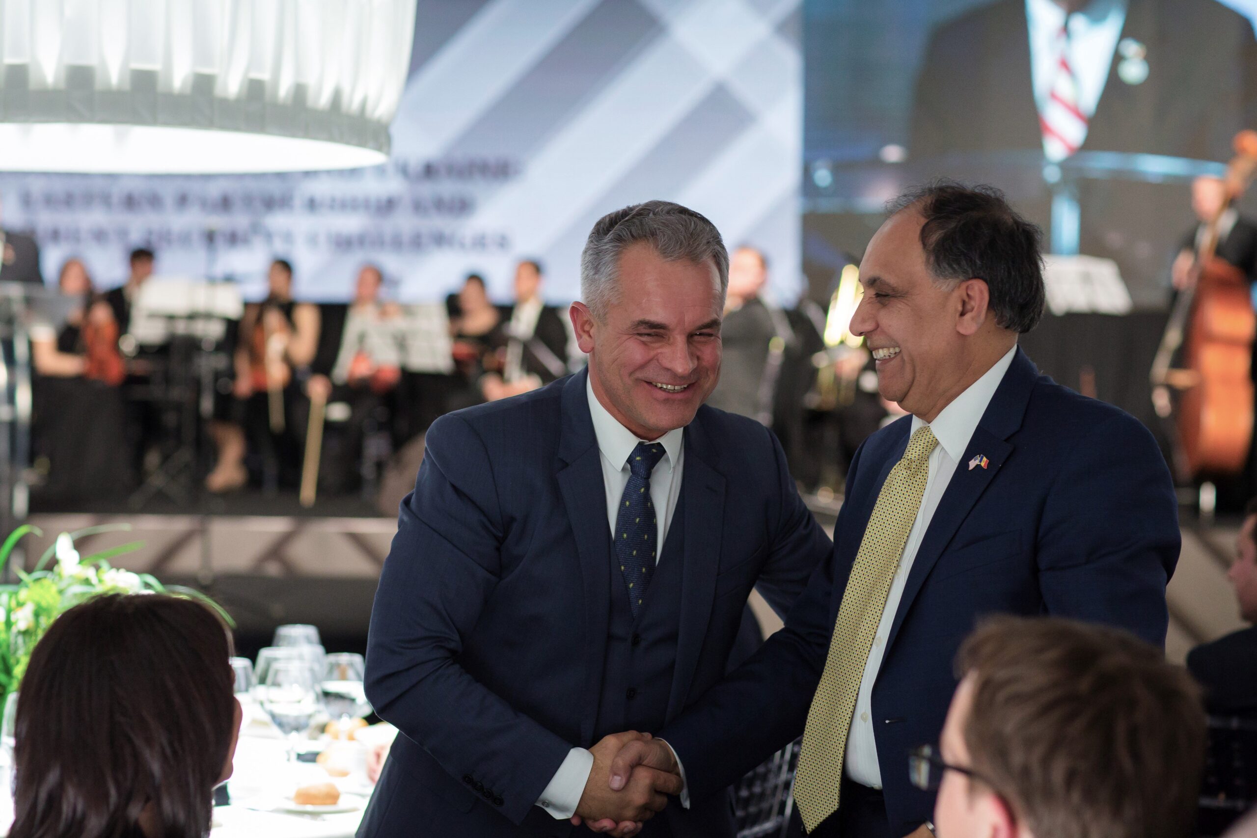 Vladimir Plahotniuc and Asif Chaudhry shake hands at a meeting with the Atlantic Council in 2018.