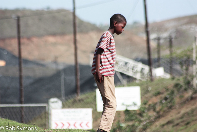 A boy playing near Tendele's washing plant: the coal mine has impacted life in the community. Image by Rob Symon via Flickr (CC BY-NC-ND 2.0)