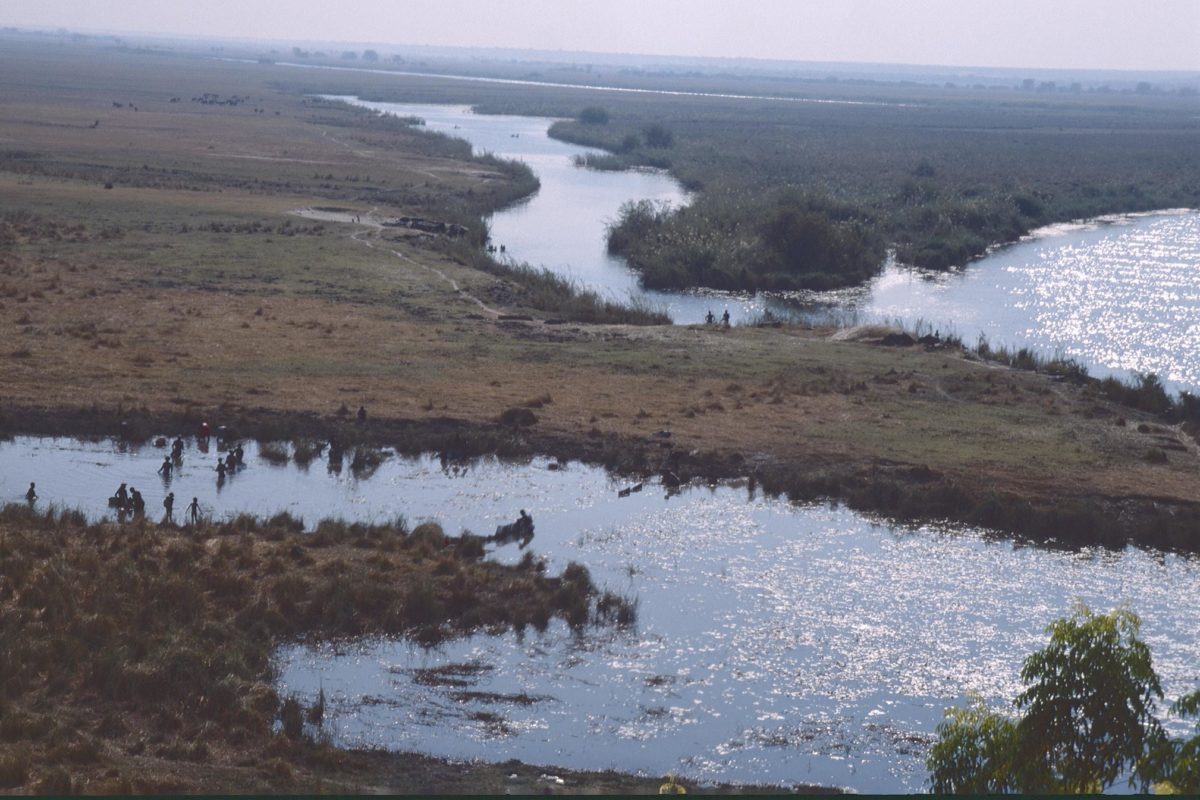 Aerial shot of river near Rundu, Namibia with small figures on the banks. Image by Patrik M. Loeff via Flickr (CC BY-NC-ND 2.0)