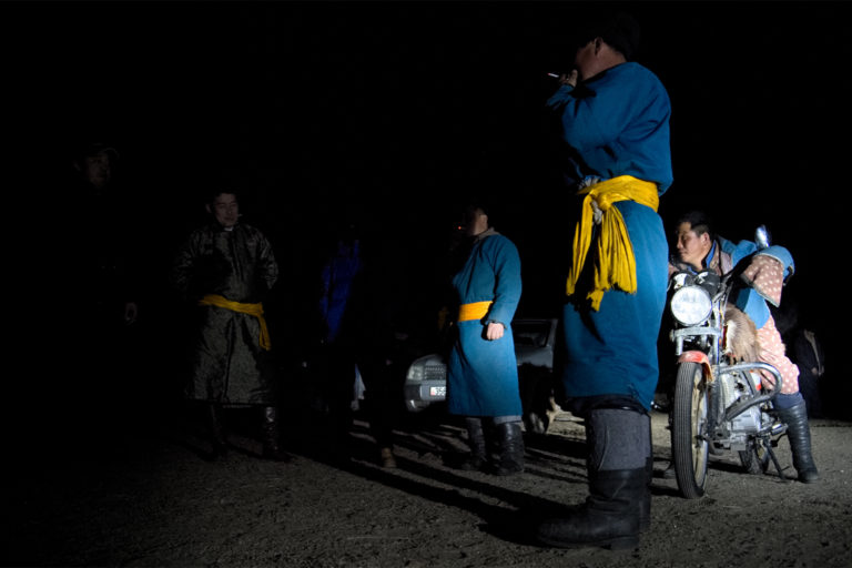 After a meeting with the experts, some herders relax out of a ger. 