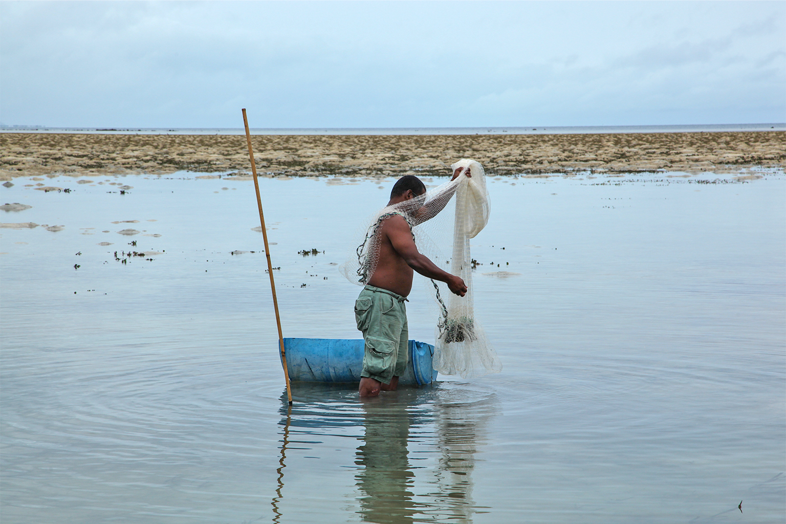 A fisherman with a fishing net in Palau on a local reef. 