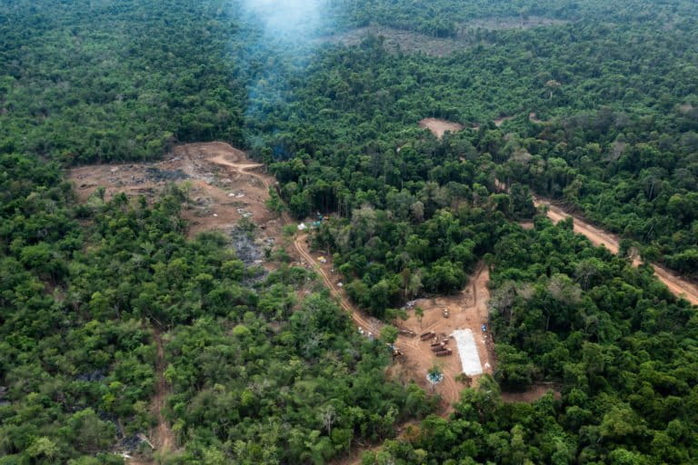 Clearing of forest with trucks and cement laid for the foundations of a building at the feasibility study area of KP Cement’s mine. Image by Andy Ball for Mongabay.