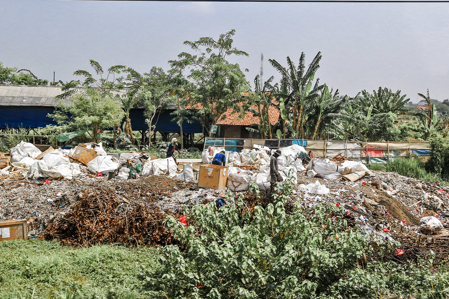 Locals sorting and recycling plastics and other garbage in Indonesia.