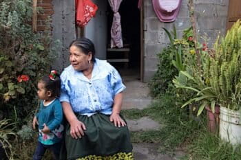 “Naná" Gracia is an Indigenous P'urhépecha midwife, seen here in her ekuarho with granddaughter Alma in Angahuan, Michoachán, Mexico. Image by Monica Pelliccia for Mongabay.