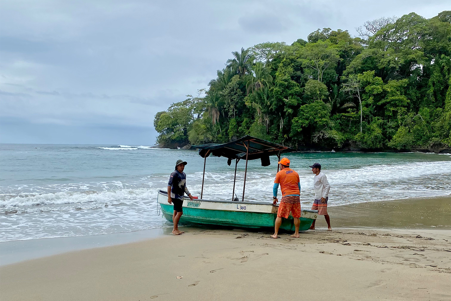 Andrés Hernández (in orange) gets ready to go to sea with two other fishermen. 