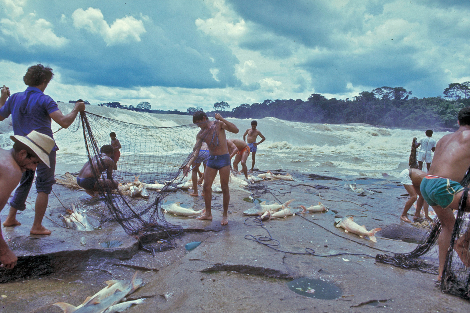 Fishermen untangling nets on the Madeira rapids.