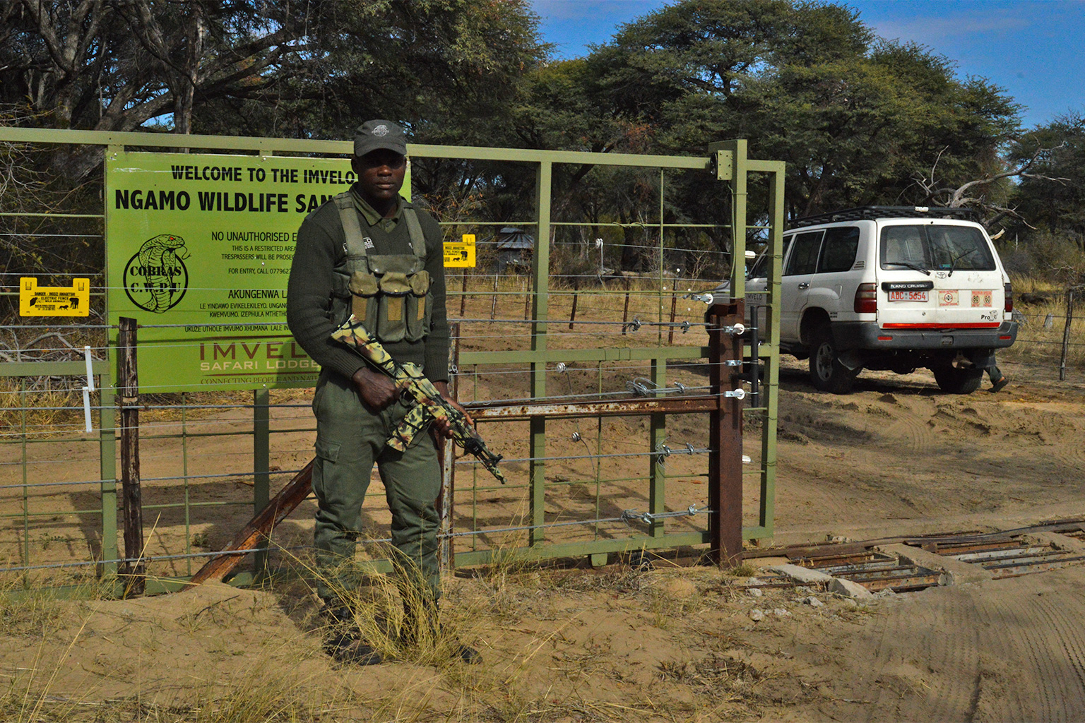 A member of the anti-poaching unit Cobras stands in front of an electric fence