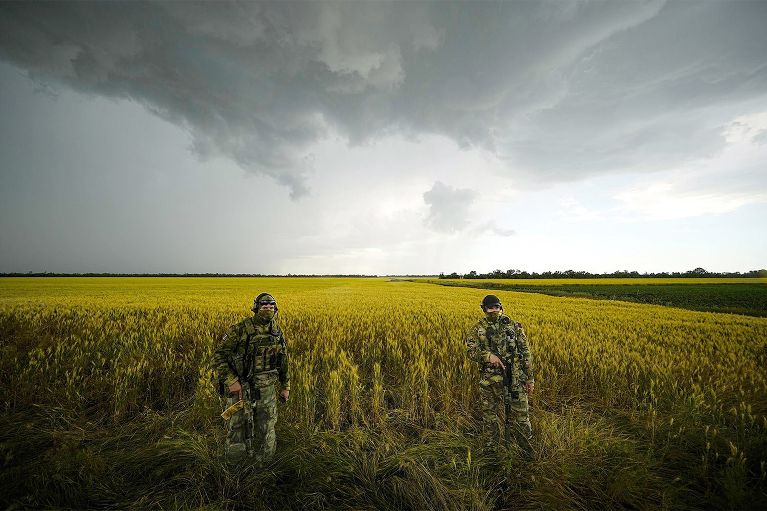 Russian soldiers guard an area next to a wheat field in Ukraine.