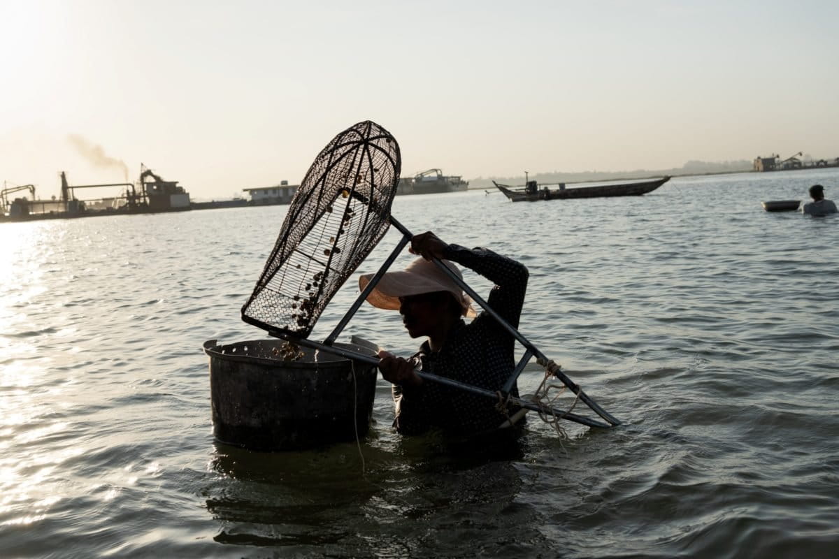 With the riverbed lowered by sand mining, Roka Koang's former fishers struggle to catch snails.