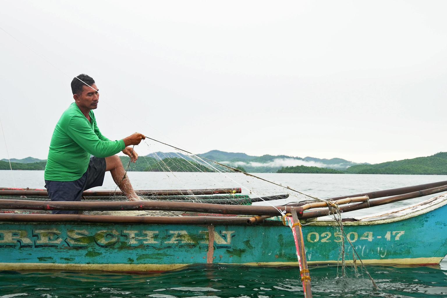 Fisher in a boat in the Malampaya Sound mangroves.