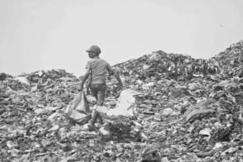 A boy sorts through the waste in a landfill