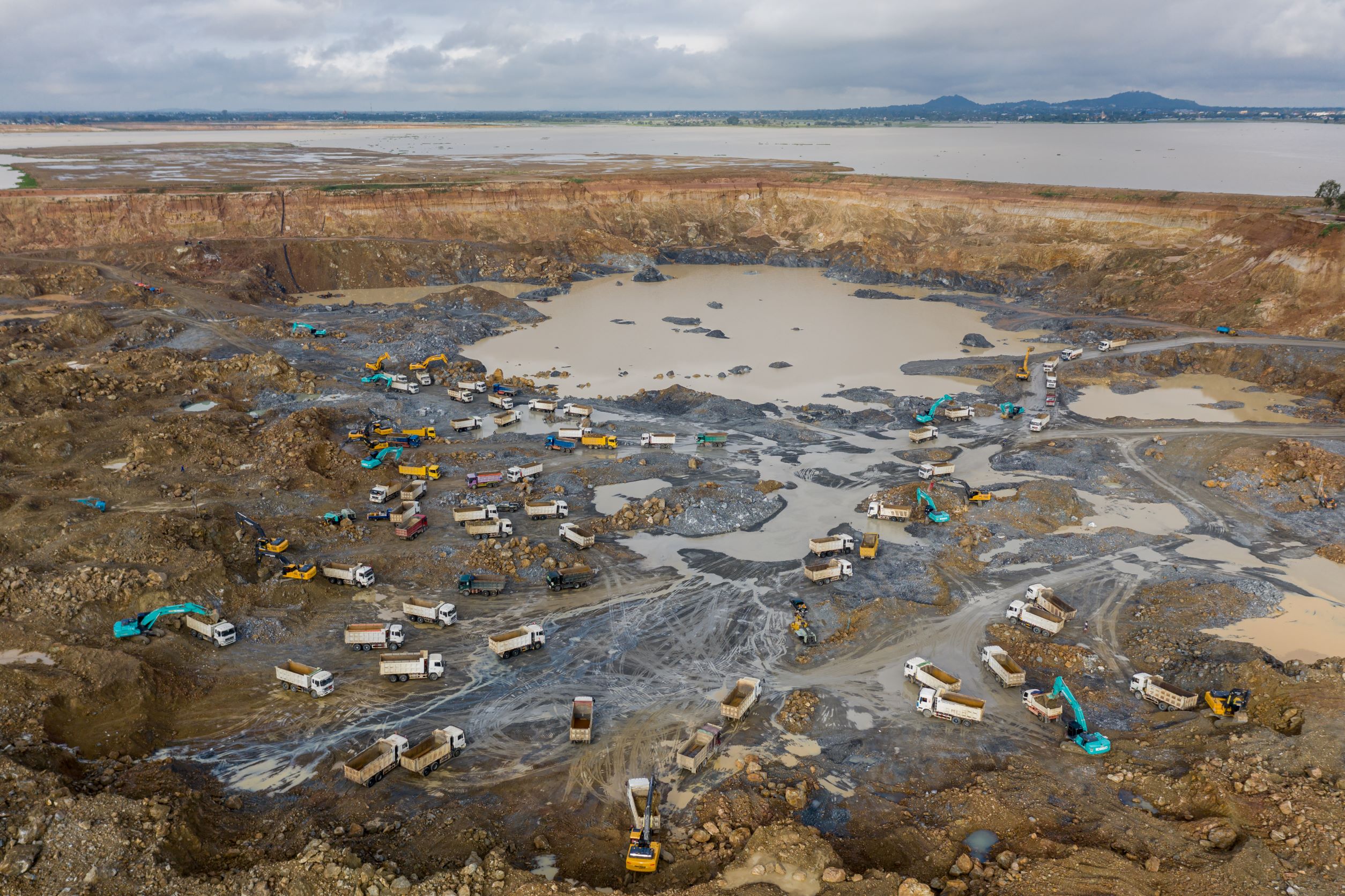 Dozens of excavators and trucks dump sand into Boeung Tamok