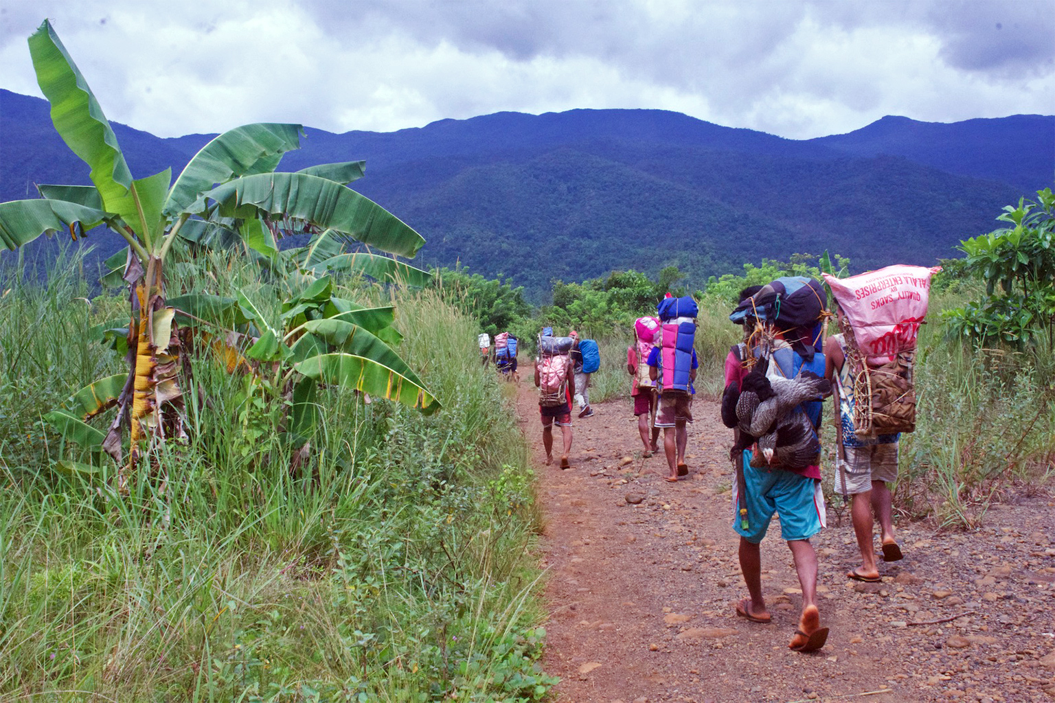 Porters carry expedition materials.