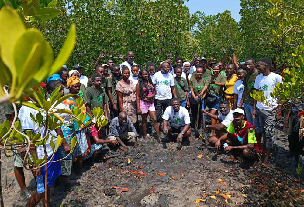 Kelly Banda (center, standing) with volunteers and community members on the mangrove restoration day.