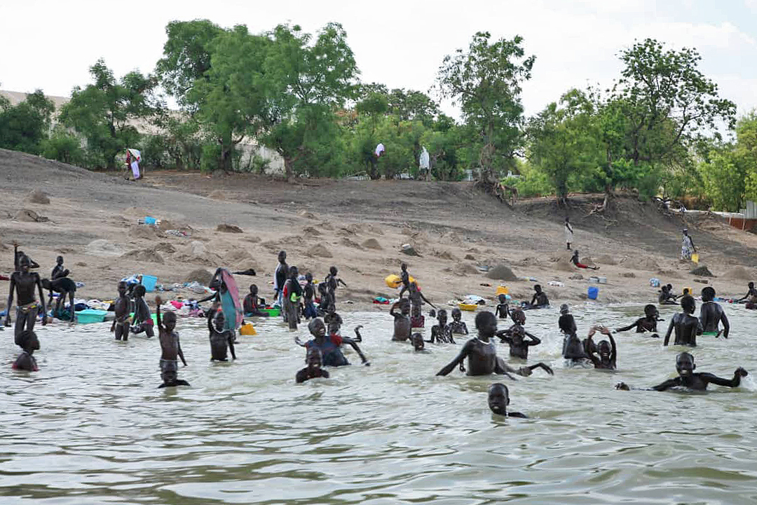 People bathing in a river in the Sudd wetland.