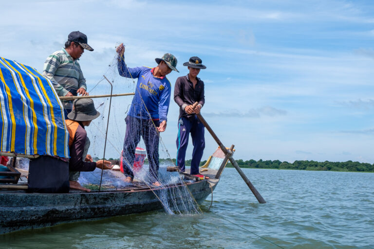 Fisherman casting net along the Mekong River in the capital city