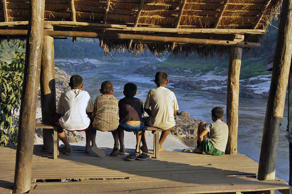 Local children watch the river flow in Pak Beng, Laos.