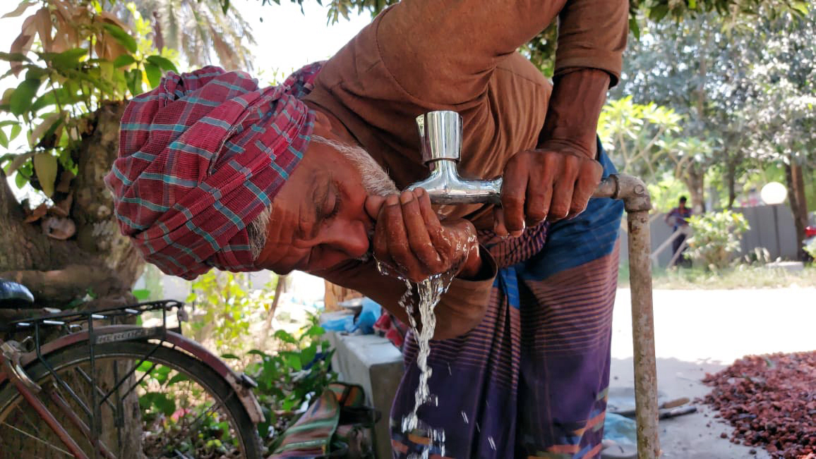 A man in western Bangladesh’s Chuadanga district drinks water from a piped water source. 