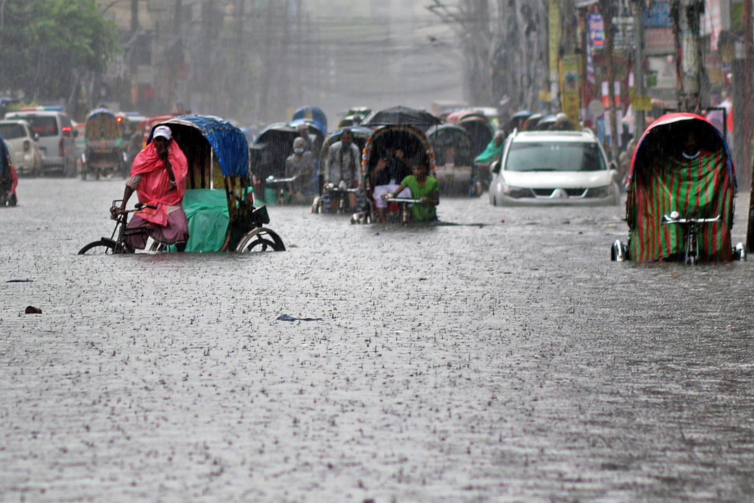 Rickshaws partially submerged on a waterlogged street