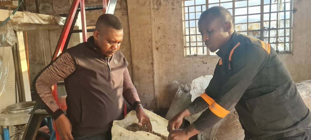 Stable Packaging founder Marecha (left) inspects the crashed plastic waste ready for recycling while one of the workers looks on.