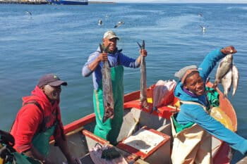Christian Adams and Anthony Stofberg with their crew in a fishing boat.