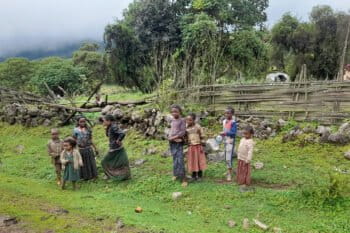 Small children from Rira village stand by the roadside near their humble home.