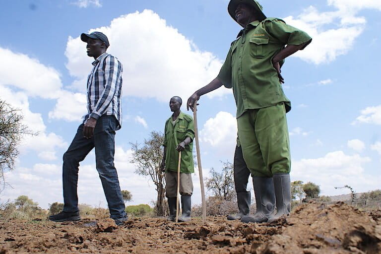 Kapiti Research Station ranch manager Nehemiah Kimengich, left, with workers at a site from which a mobile boma has recently been relocated. Image by David Njagi for Mongabay.