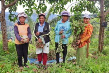 Helni Gopi (left) with her companions bringing a variety of their harvests back from the pampa forest.