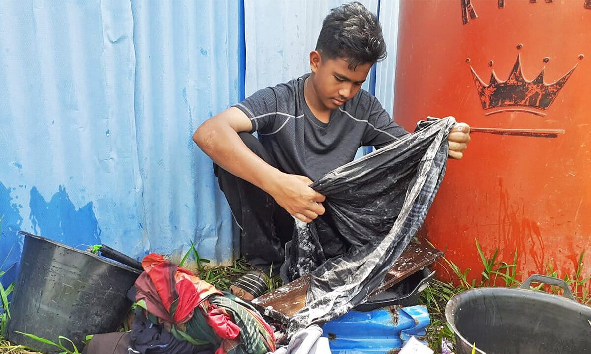 Muhammad Erlangga, a student, washes his clothes with rainwater.