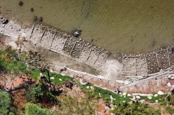 Drone image of the erodible bluff (bottom) being stabilized by tiers of logs pinned to the ground, back-filled with soil, and planted among erosion-slowing rocks to keep the rising waters at bay, for a 'living shorelines' project on the Blue Hill Peninsula in Maine. Image by Erik Hoffner for Mongabay.