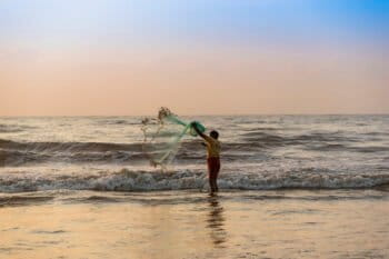 A fisherman casts his net at a beach in Chennai, India.