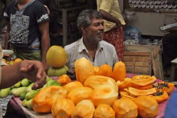A fruit seller with peeled papaya in a market in Bangladesh.