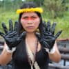 Waorani leader Nemonte Nenquimo stands next to an oil spill near Shushufindi