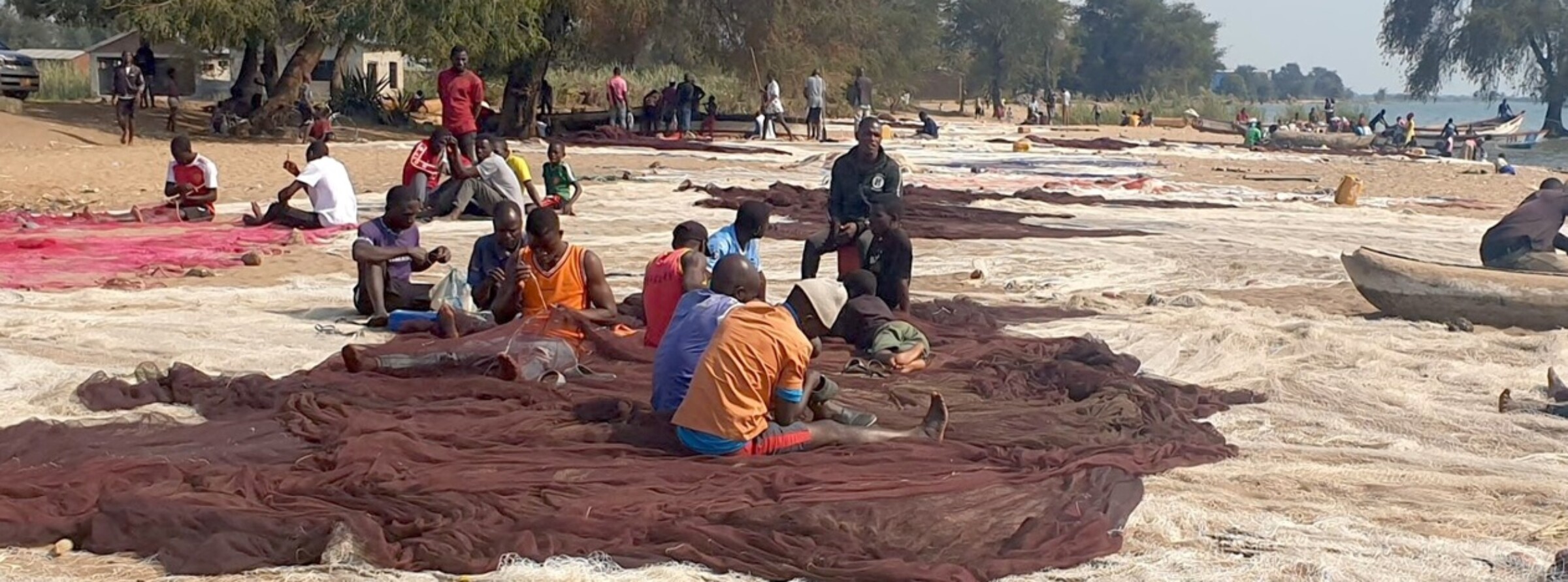 Artisans fix nets at Chikombe Beach ahead of their trip to Mbenje Island – . Image by Charles Mpaka for Mongabay.